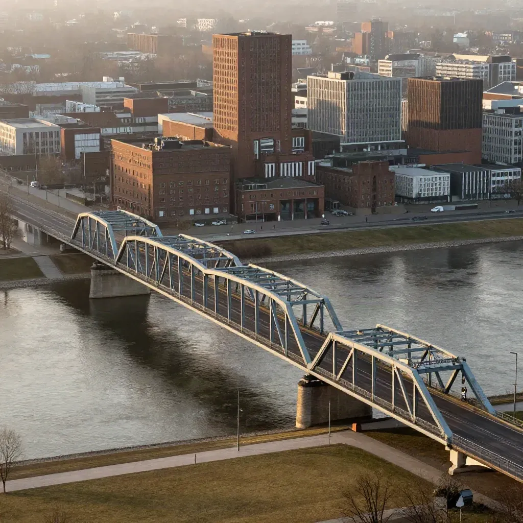 Hochblick auf Rhein-Ruhr: Stahlbrücke, Flusskurve und Industrie im warmen Dunst.